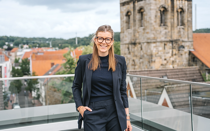 Eine Partnerin der Steuerkanzlei Runde Glüsing Baune steht lächelnd auf der Dachterrasse mit Blick auf die Innenstadt von Ibbenbüren