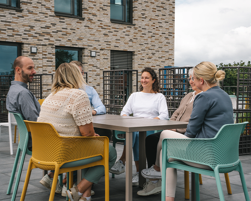 Mitarbeitende der Kanzlei Runde Glüsing Baune sitzen bei einem Teammeeting auf der Dachterrasse in Ibbenbüren